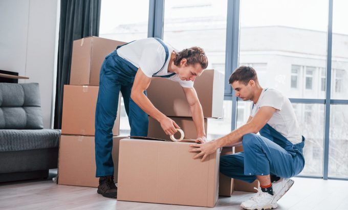 packaging-box-two-young-movers-blue-uniform-working-indoors-room-min Moving Service